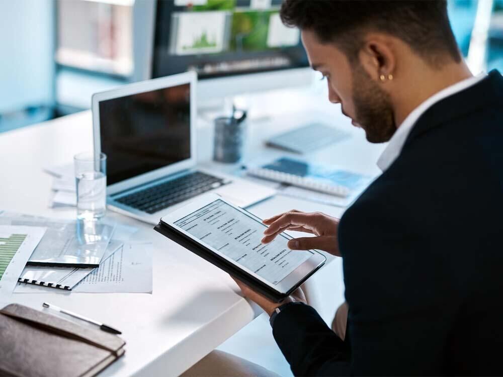 Archivage numérique de documents comptables sur ordinateur et tablette en entreprise.